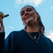 girl holding an ice cream cone with blue sky behind